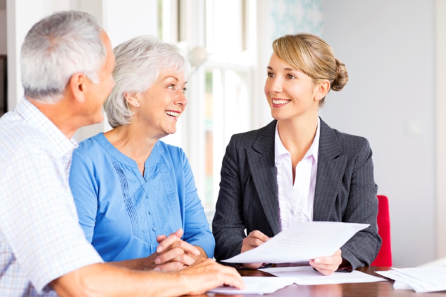 uma advogada conversando com dois idosos sobre direito previdenciário